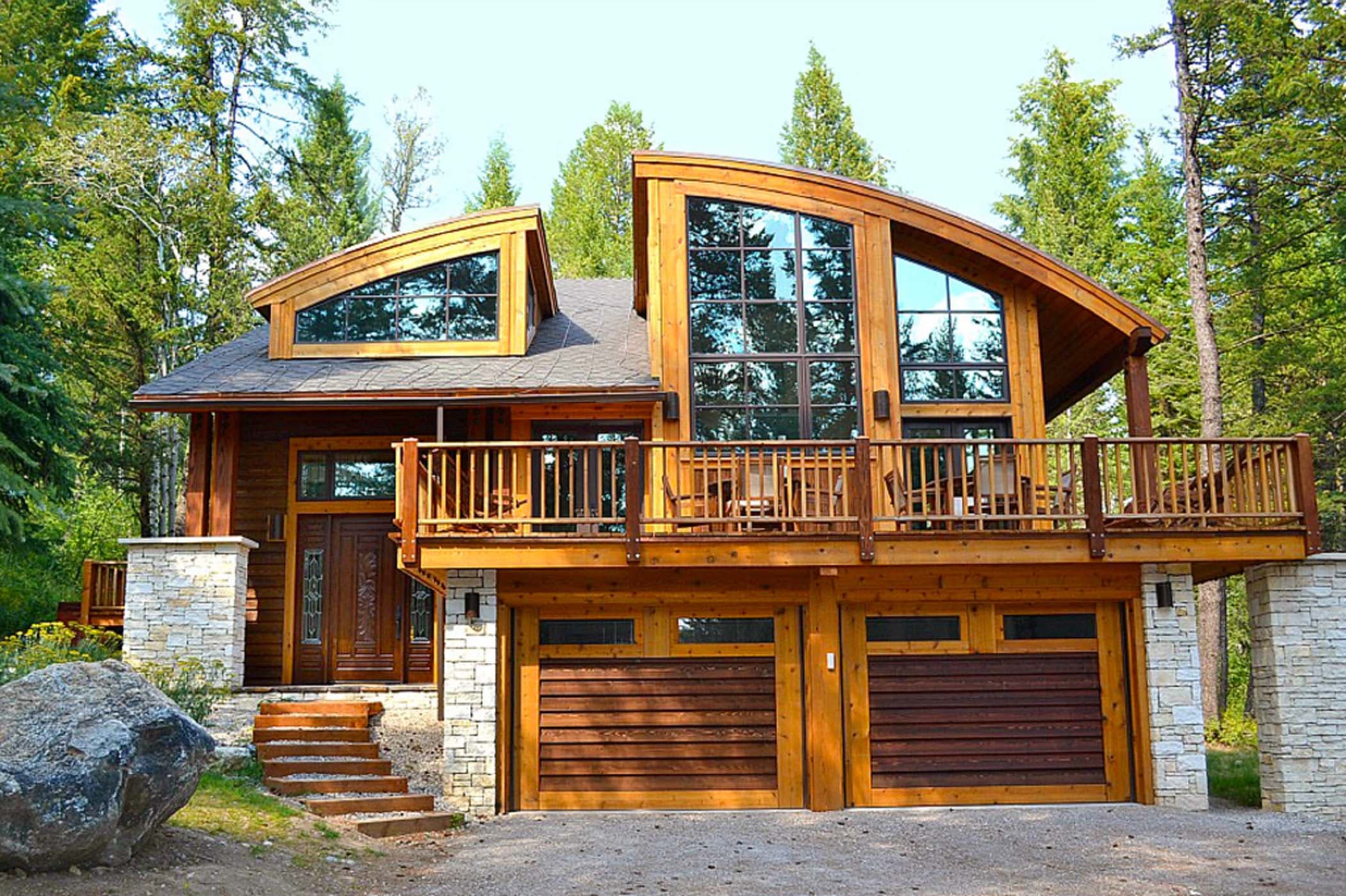 The exterior of the Blue Moose Lodge during the day with beautiful large window, a double garage, and a wrap around deck at Teton Private Residences