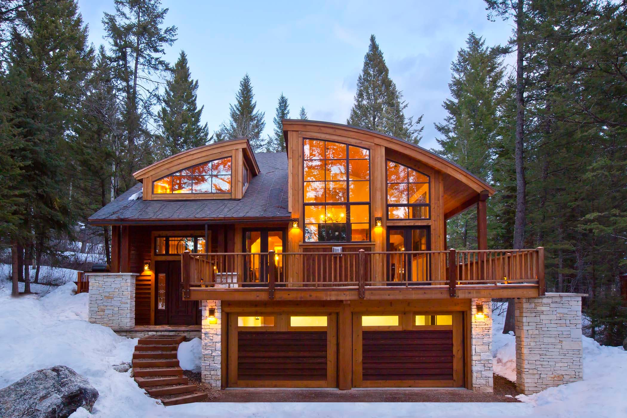 The exterior of the Blue Moose Lodge with beautiful large window, a double garage, and a wrap around deck at Teton Private Residences