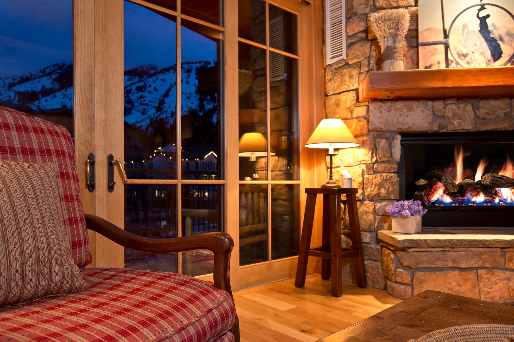 A close up of a table lamp on beside a fireplace in the Paintbrush living room at Teton Private Residences