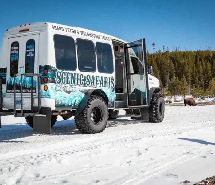 A Wildlife Safari bus stopped in the snow ahead of touring Grand Teton, Wyoming